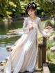 A woman in a white dress standing on a wooden bridge.