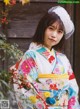 A woman in a colorful kimono poses for a picture.