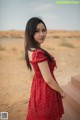 A woman in a red polka dot dress posing for a picture.