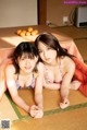 A couple of women laying on top of a tatami mat.