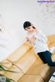 A woman sitting on top of a yellow couch.