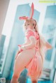 A woman in a pink bunny costume posing for a picture.