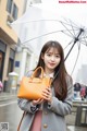 A woman holding an umbrella while standing in the rain.