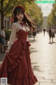 A woman in a red dress is walking down the street.