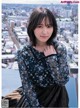 A woman in a black dress standing on top of a building.