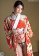 A woman in a red and white kimono posing for a picture.