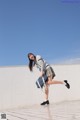 A woman in a school uniform is jumping in the air.